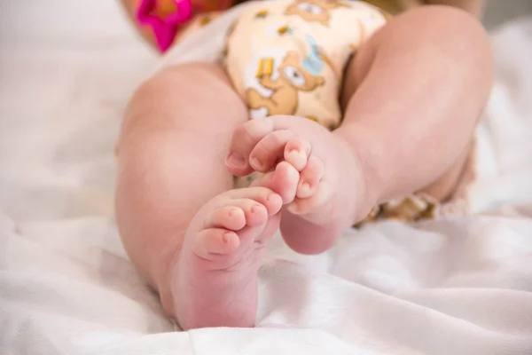 Baby in modern eco stacks of cloth diapers and replacement bushings selective focus close-up on bright background — Stock Photo, Image