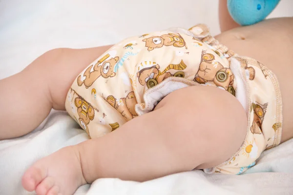Bebê em modernas pilhas ecológicas de fraldas de pano e buchas de substituição foco seletivo close-up no fundo brilhante — Fotografia de Stock