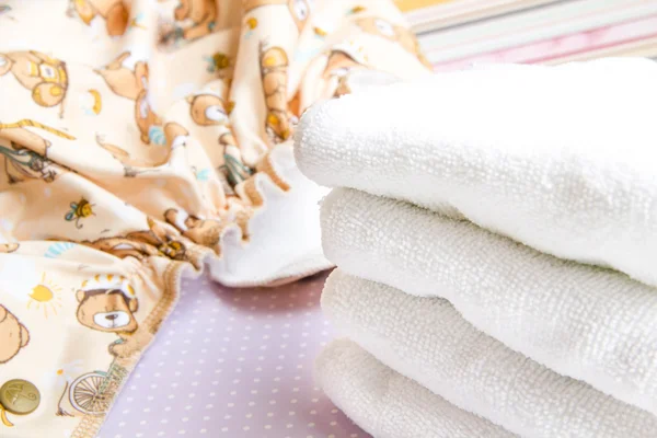 Modern eco stacks of cloth diapers and replacement bushings selective focus close-up on bright background — Stockfoto