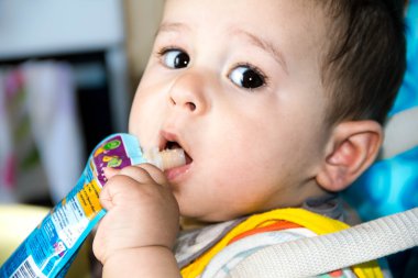 sandalye ve yemek yiyecek bir tüp başına çocuk oturuyor mutlu bebek çocuk paket tutuyordu meyve püresi, kaybetmek-up, mutfakta, besleme başlangıç