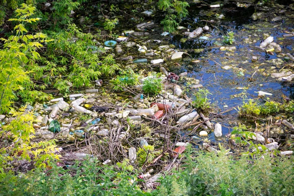 Illegal bulk waste discarded. Landfill in the river. polluted environment.  problem concept