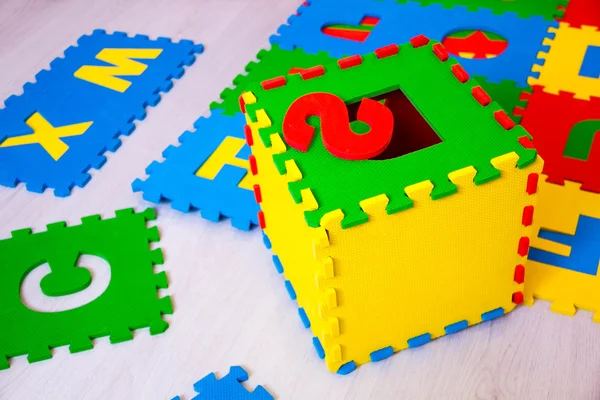 Barn pussel med bokstäver på grå trä bakgrund, begreppet skolutbildning, — Stockfoto