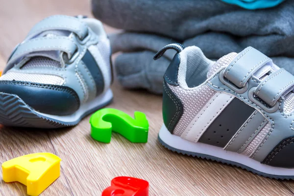 Baby winter kleding, concept, herfst, sneakers, caps, speelgoed. Hoe te kleden van de baby in de winter. Kies de schoenen. — Stockfoto