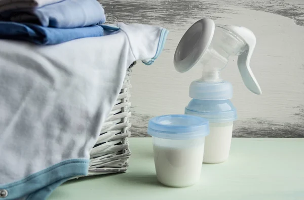 Background of manual and automatic breast pump, baby bottle with milk.