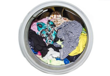 A yakın çekim, modern bir çamaşır makinesi beyaz arka plan üzerinde izole giysileri ile yüklü. Çamaşır makinesi kirli giysiler, closeup tam. yakma makinesi penceresi