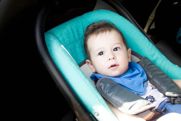 Portrait of toddler boy in car seat. Little smiling baby child fastened with a seat belt portrait of adorable happy baby boy sitting in the car seat. concept in safety in the car. — Stock Photo, Image