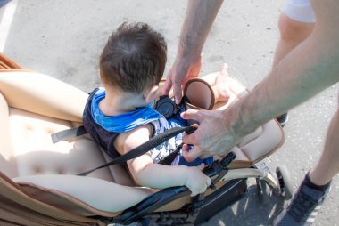 Bebek arabası bebek babası yürür. Ebeveynlik ve annelik babalık bırak. Babası askısı Bebek arabasındaki bebek, Emanet kavramı bebek baba oğlu bebek arabası içinde bir açık yaz günü koyar