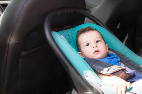 Portrait of toddler boy in car seat. Little smiling baby child fastened with a seat belt portrait of adorable happy baby boy sitting in the car seat. concept in safety in the car. — Stock Photo, Image