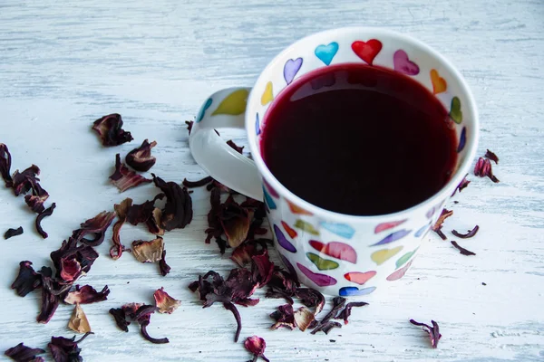 Concetto d'amore, tazza di tè rosso, forma di cuore sul pavimento in legno . — Foto Stock