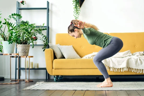 Bella giovane donna che fa yoga a casa. Allenamento fitness online. — Foto Stock