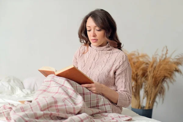 아침에 침대에 누워 있는 아름다운 여인의 부드러운 초상화. 독서 책 — 스톡 사진