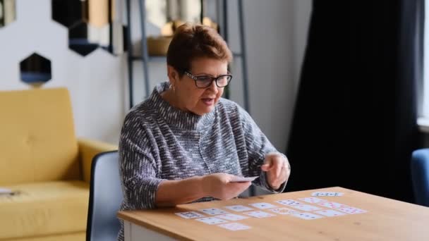 Senior femme jouant solitaire à la maison. Bonne vieille dame joue un jeu intellectuel close up Shot vidéo. — Video