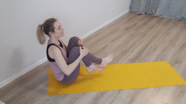 Mulher bonita fazendo ioga em casa. asanas no tapete de ioga. De tonificação vintage. close up Filmado vídeo. Movimento lento. — Vídeo de Stock