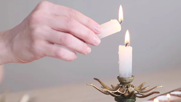 Mano humana encendiendo la vela. Oración, fe, concepto religioso. enfoque selectivo — Foto de Stock