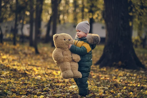 Bonito menino brincando ao ar livre. Criança feliz andando no parque de outono. Menino bebê usa jaqueta da moda. Moda de outono. Criança elegante fora. — Fotografia de Stock