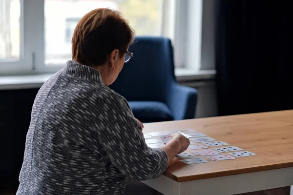 Mujer mayor jugando solitario en casa. Feliz anciana juega un juego intelectual — Foto de Stock