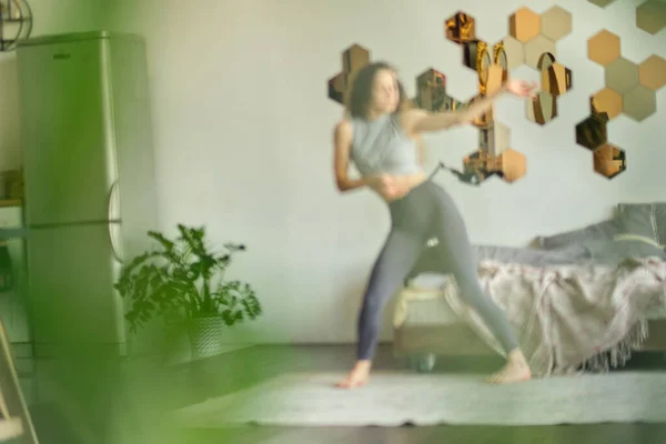 graceful woman dances in her house presenting herself on stage. happy woman dance enjoy leisure at home, stress free concept. concept of freedom and self-acceptance. soft focus. blurry bokeh