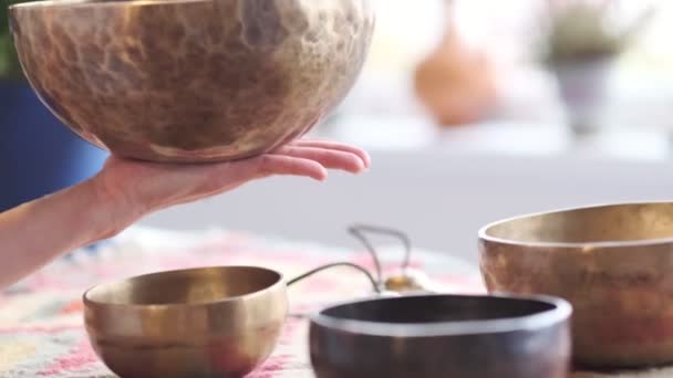 Donna che gioca sulla ciotola tibetana mentre siede sul tappetino yoga. Annata tonica. filmati di magazzino. Video del rallentatore. Da vicino. — Video Stock