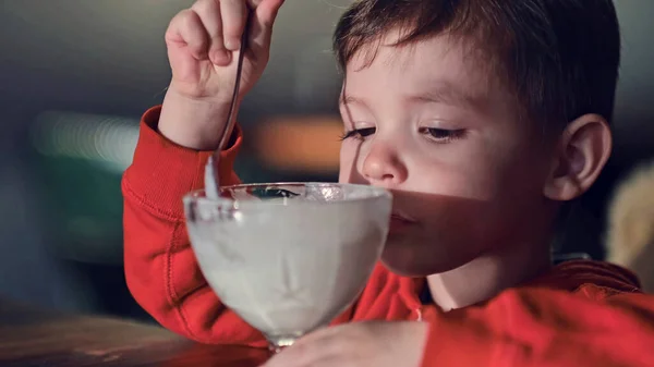 Little boy eating ice cream in cafe. Cute child, enjoying vanilla yogurt in a restaurant — Stock Photo, Image