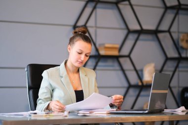 Meşgul kadın ofis çalışanı. Ciddi genç bayan çalışanlar ofiste dizüstü bilgisayarıyla çalışıyorlar. etkin çalışan.