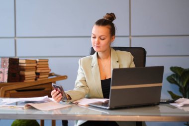 Ciddi genç bayan çalışanlar ofiste dizüstü bilgisayarıyla çalışıyorlar. Etkili çalışan. Etrafımızı çevreleyen dijital görüntüler