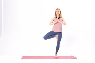 Orta yaşlı kadın yogası. Eğitmen yoga pozu gösteriyor. Beyaz bir arka planda izole edilmiş. Yoga yapan bir kadın. Vücut ve zihinsel gelişim arasındaki doğal denge..