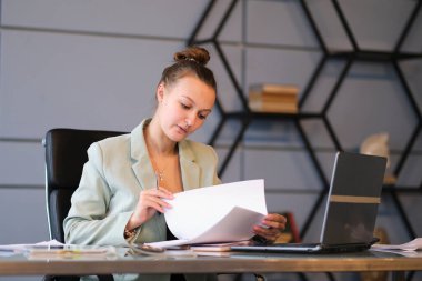 Meşgul kadın ofis çalışanı. Ciddi genç bayan çalışanlar ofiste dizüstü bilgisayarıyla çalışıyorlar. etkin çalışan.