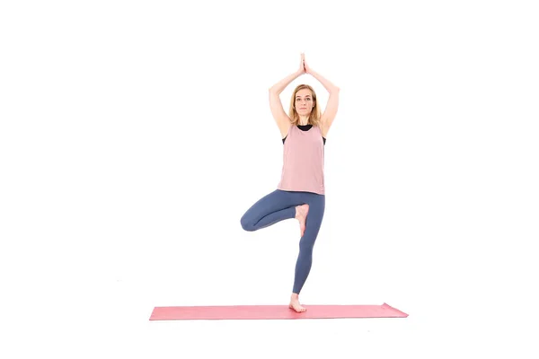 Mujer de mediana edad yoga asanas. instructor muestra una pose de yoga aislado sobre un fondo blanco. mujer practicando yoga concepto equilibrio natural entre el cuerpo y el desarrollo mental. —  Fotos de Stock