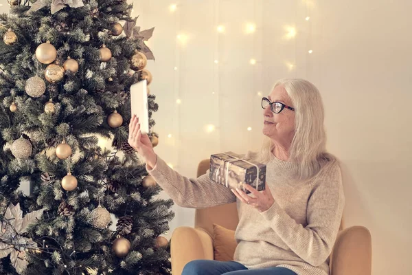 Senior woman talking with family during online call . Happy grandmothers during video conference celebrating winter holidays. soft focus, warm tones