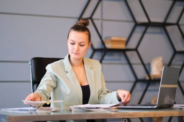 Meşgul kadın ofis çalışanı. Ciddi genç bayan çalışanlar ofiste dizüstü bilgisayarıyla çalışıyorlar. etkin çalışan.