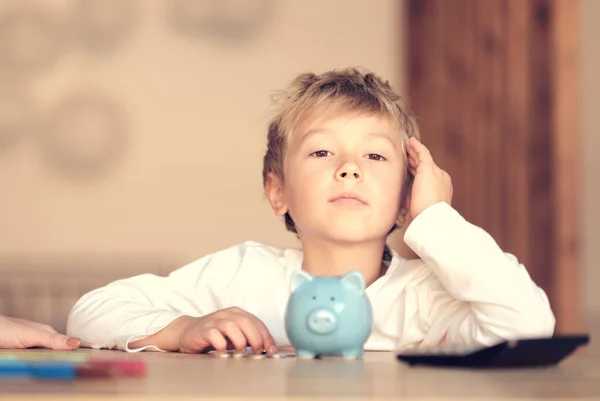 Niño, dinero, inversión y gente feliz concepto sonriente niño con alcancía y dinero en casa —  Fotos de Stock