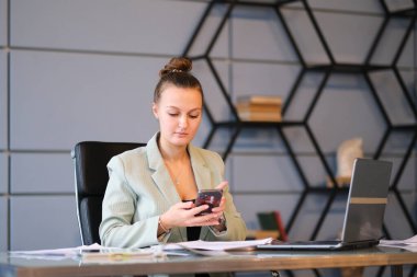 Meşgul kadın ofis çalışanı. Ciddi genç bayan çalışanlar ofiste dizüstü bilgisayarıyla çalışıyorlar. etkin çalışan