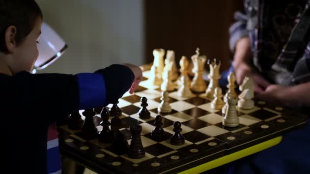 Grootmoeder schaakt thuis met haar kleinzoon. Van dichtbij gezien. Slow motion beelden. Opgenomen video. — Stockvideo