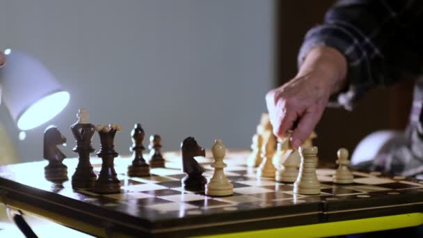 Die Großmutter spielt zu Hause mit ihrem Enkel Schach. Nahsicht. Zeitlupenaufnahmen. Aufgenommenes Video. — Stockvideo