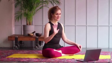 Çevrimiçi spor fitness yoga antrenmanı. Evde dizüstü bilgisayar karşısında egzersiz yapan bir kadın. Yoga asanası. Beden ve zihinsel gelişim arasındaki denge. Manzarayı kapat. Yavaş çekim videosu. depolama görüntüleri