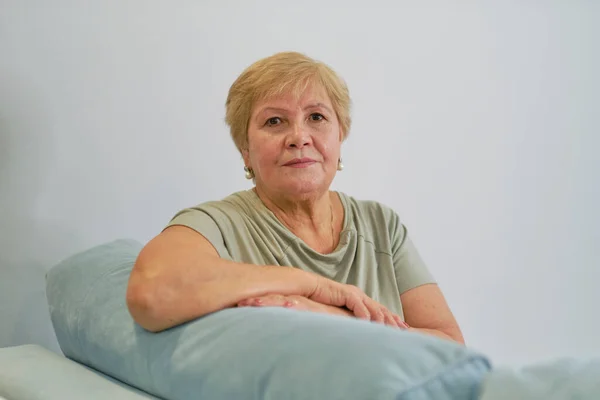 Prise de vue d'une femme âgée heureuse souriante regardant loin Portrait d'une dame mature élégante assise sur le canapé à la maison — Photo