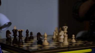 Büyükannesi evde torunuyla satranç oynuyor. Manzarayı kapat. Yavaş çekim. Çekilen video.