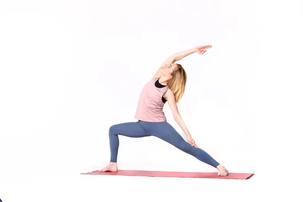 Asanas de ioga de mulher de meia idade. instrutor mostra uma pose de ioga isolado em um fundo branco. mulher praticando ioga conceito equilíbrio natural entre corpo e desenvolvimento mental. — Fotografia de Stock