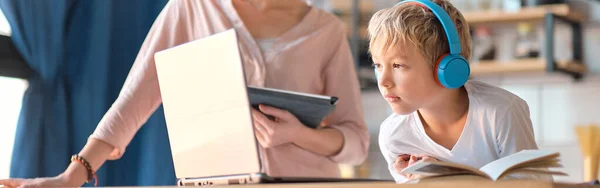 Maman aidant le jeune fils avec ordinateur portable à faire ses devoirs. Une jeune femme apprend à un petit garçon à utiliser l'ordinateur. baby-sitter enseignement petite fille enfant utilisation application ordinateur portable. — Photo