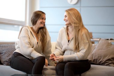 Mutlu kıdemli anne, yetişkin kızı kucaklıyor birlikte gülüyor, heyecanlı yaşlı kadın sarılıyor, farklı nesillerden gelen samimi aile şakalaşıyor, eğleniyor.