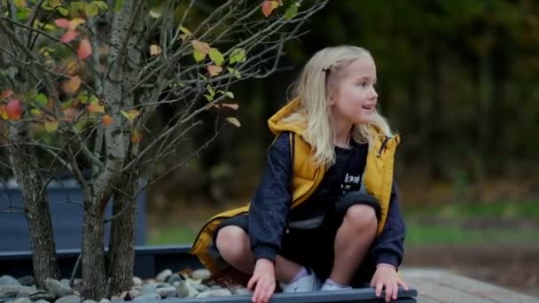 Linda menina olha para o lado, bonito menina pré-escolar em roupas modernas brilhantes — Vídeo de Stock