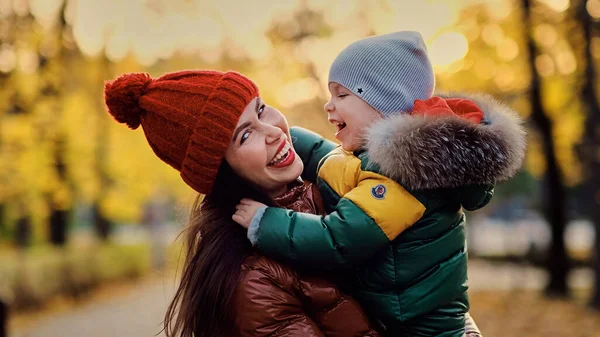 Bela jovem mãe e pequeno filho se divertir no parque. família desfrutando de um passeio na natureza. conceito de maternidade feliz. — Fotografia de Stock