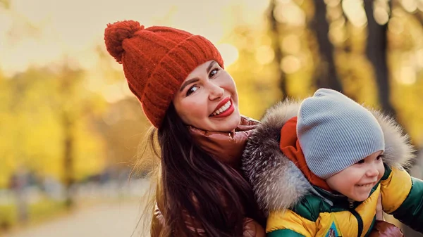 Bela jovem mãe e pequeno filho se divertir no parque. família desfrutando de um passeio na natureza. conceito de maternidade feliz. — Fotografia de Stock