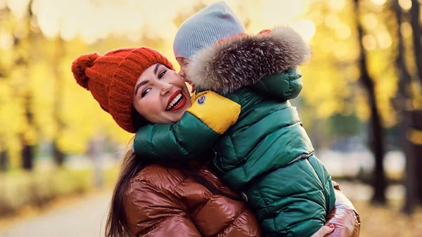Beautiful young mom and little son have fun in the park. family enjoying a walk in nature. happy motherhood concept. soft focus — Stock Photo, Image