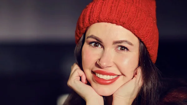 Primer plano retrato de mujer hermosa con ojos marrones en sombrero rojo de punto. sonrisa feliz. vista de cerca. — Foto de Stock