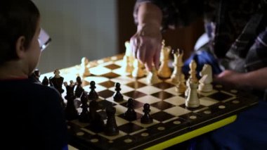 Büyükannesi evde torunuyla satranç oynuyor. Manzarayı kapat. Yavaş çekim. Çekilen video.