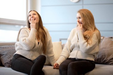 Mutlu kıdemli anne, yetişkin kızı kucaklıyor birlikte gülüyor, heyecanlı yaşlı kadın sarılıyor, farklı nesillerden gelen samimi aile şakalaşıyor, eğleniyor.