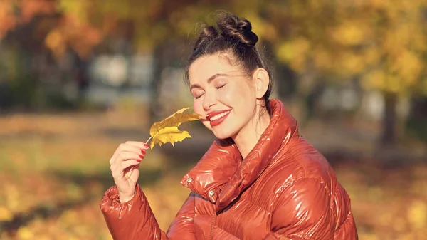 Heureuse femme souriante tenant dans ses mains feuilles d'érable jaune couvrant son oeil sur l'automne Nature Contexte — Photo