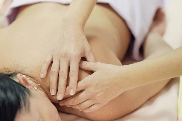 Fisioterapeuta Massagear as costas e ombros de uma paciente do sexo feminino. Sobre a visão do ombro do massagista realizando massagem profunda do tecido das mulheres de volta para liberar a dor — Fotografia de Stock