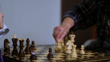 Büyükannesi evde torunuyla satranç oynuyor. Manzarayı kapat. Yavaş çekim. Çekilen video.